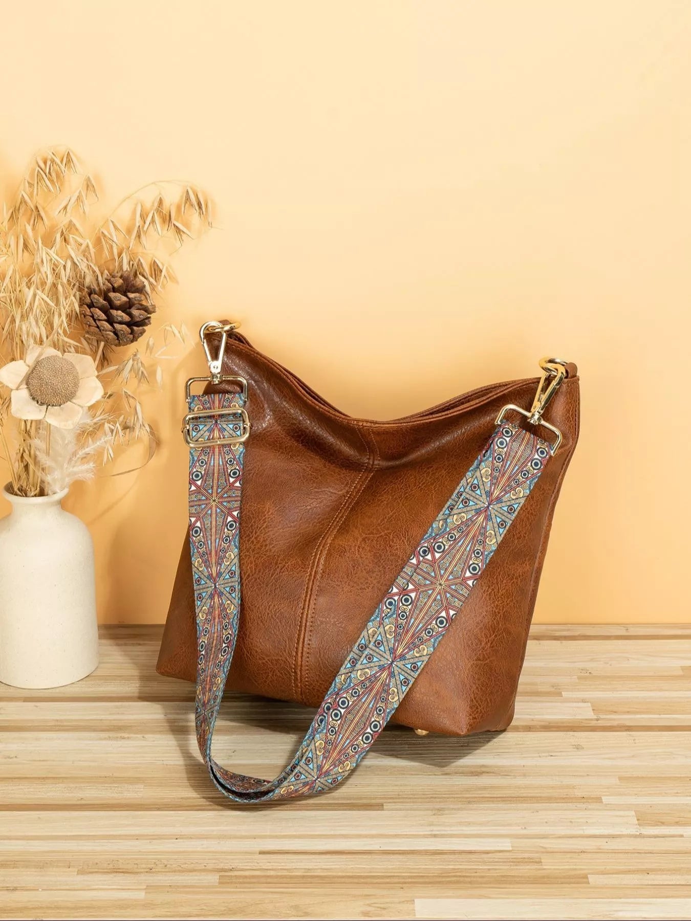Medium PU leather tote bag with wide patterned mosaic strap and structured silhouette.