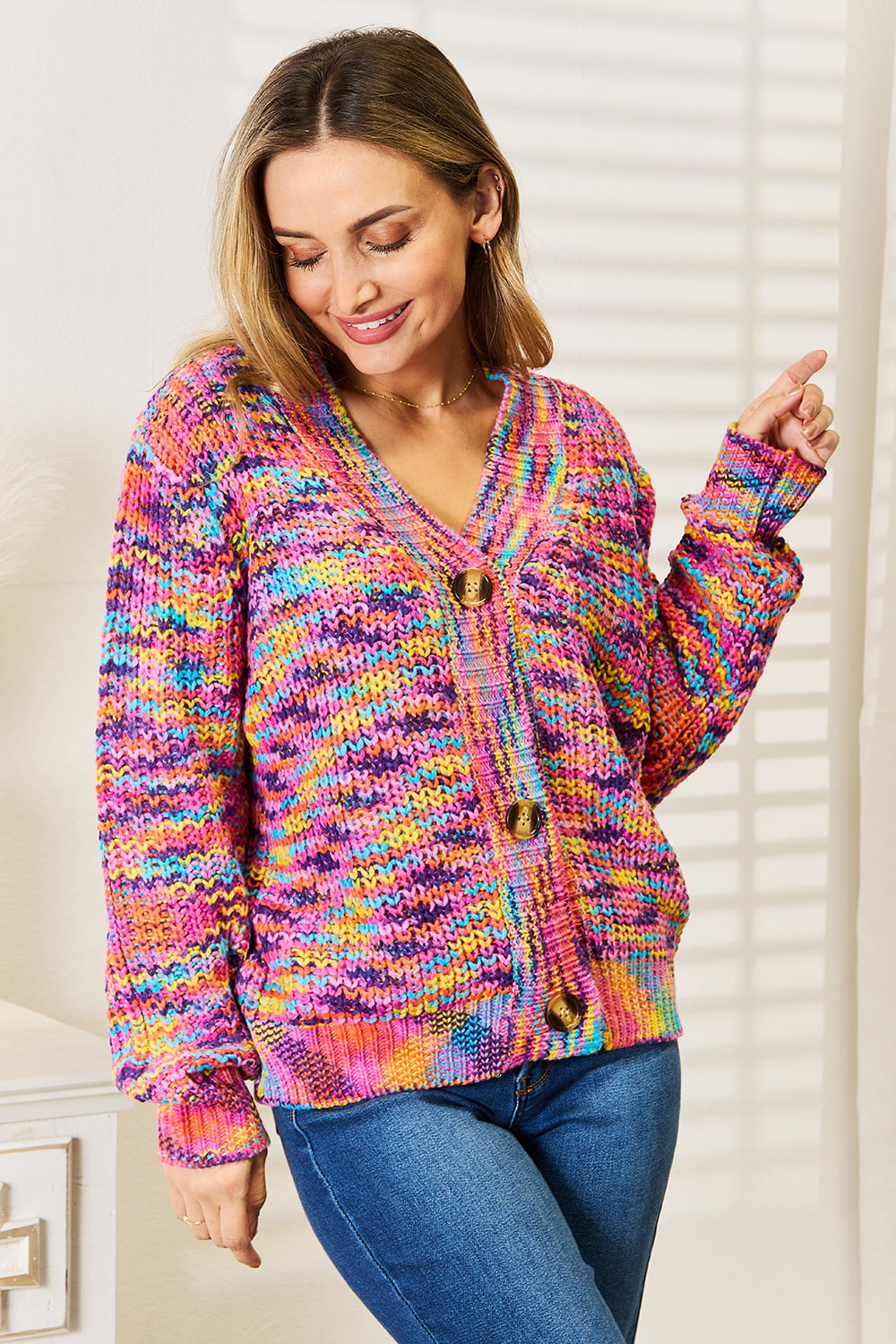 Woman wearing a multicolor chunky knit cardigan with gold buttons