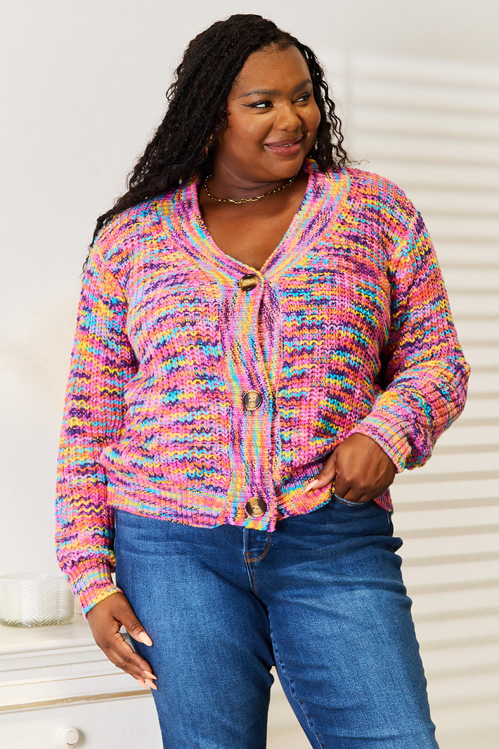 Woman wearing a multicolor chunky knit cardigan with gold buttons
