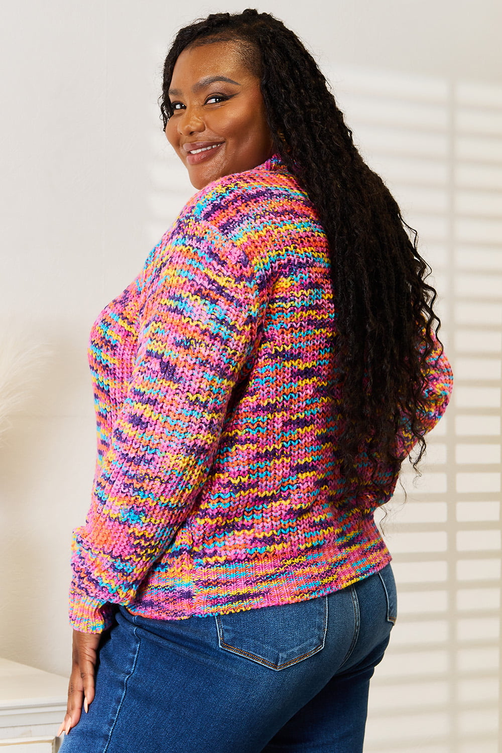 Woman wearing a multicolor chunky knit cardigan with gold buttons