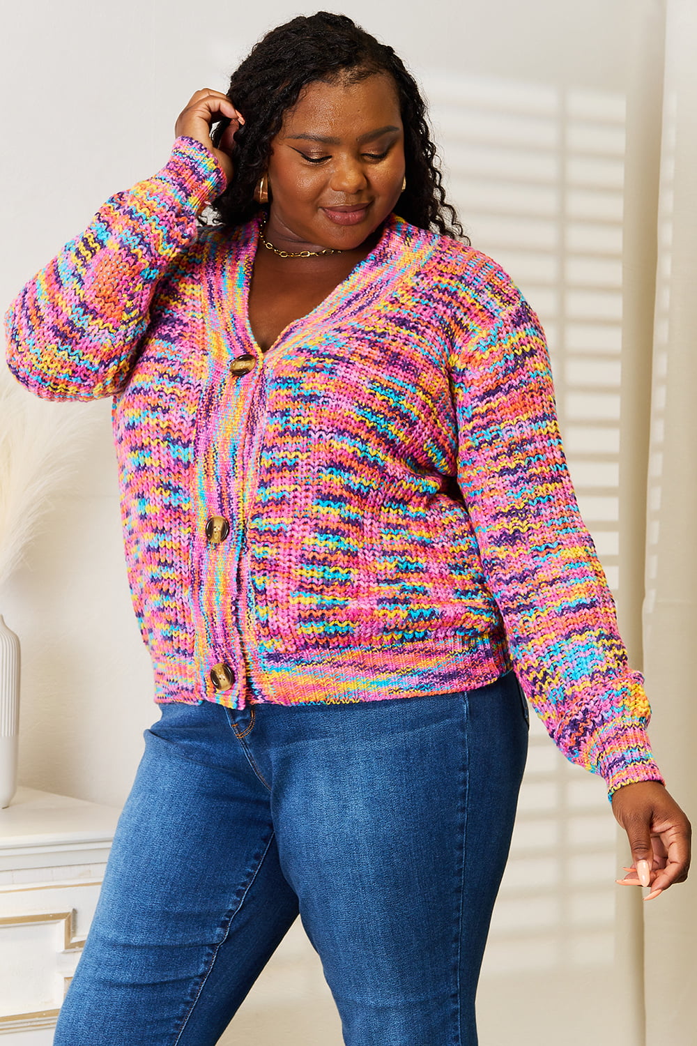 Woman wearing a multicolor chunky knit cardigan with gold buttons