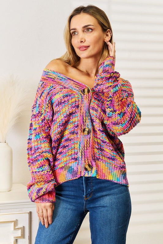 Woman wearing a multicolor chunky knit cardigan with gold buttons