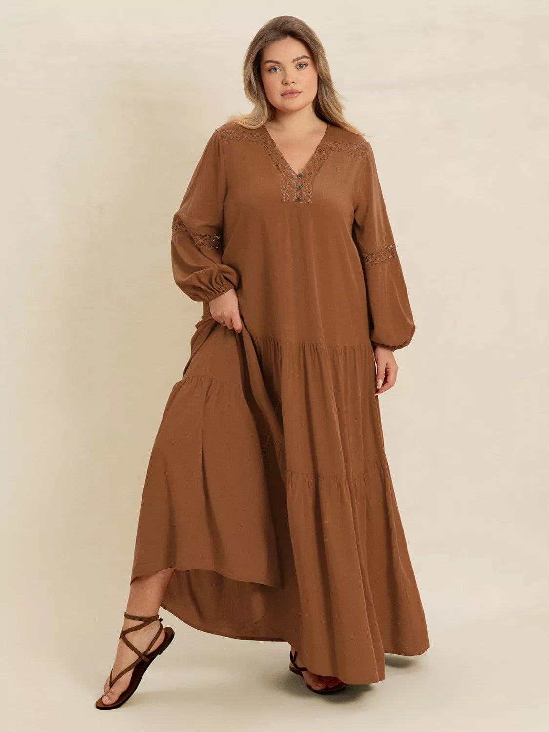 Woman wearing a camel-colored tiered maxi dress with lace detail and long sleeves — elegant flowing boho dress from A Whimsical Affair.
