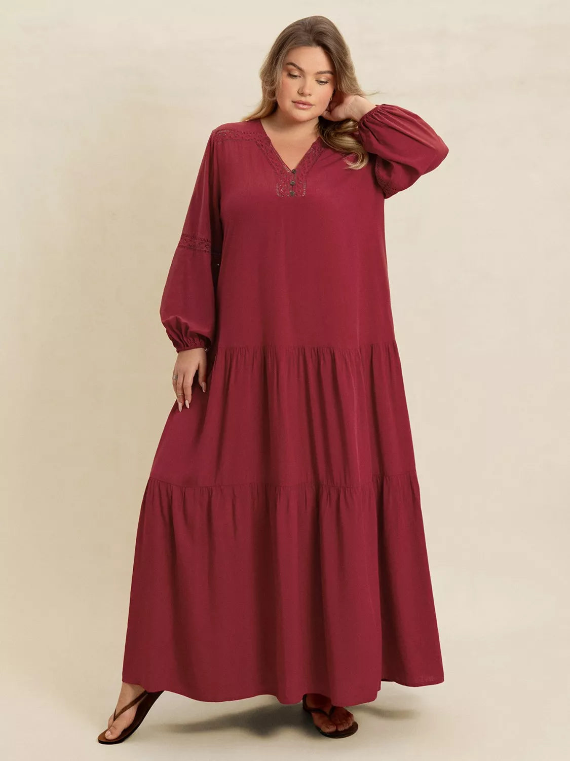 Woman wearing a burgundy-colored tiered maxi dress with lace detail and long sleeves — elegant flowing boho dress from A Whimsical Affair.
