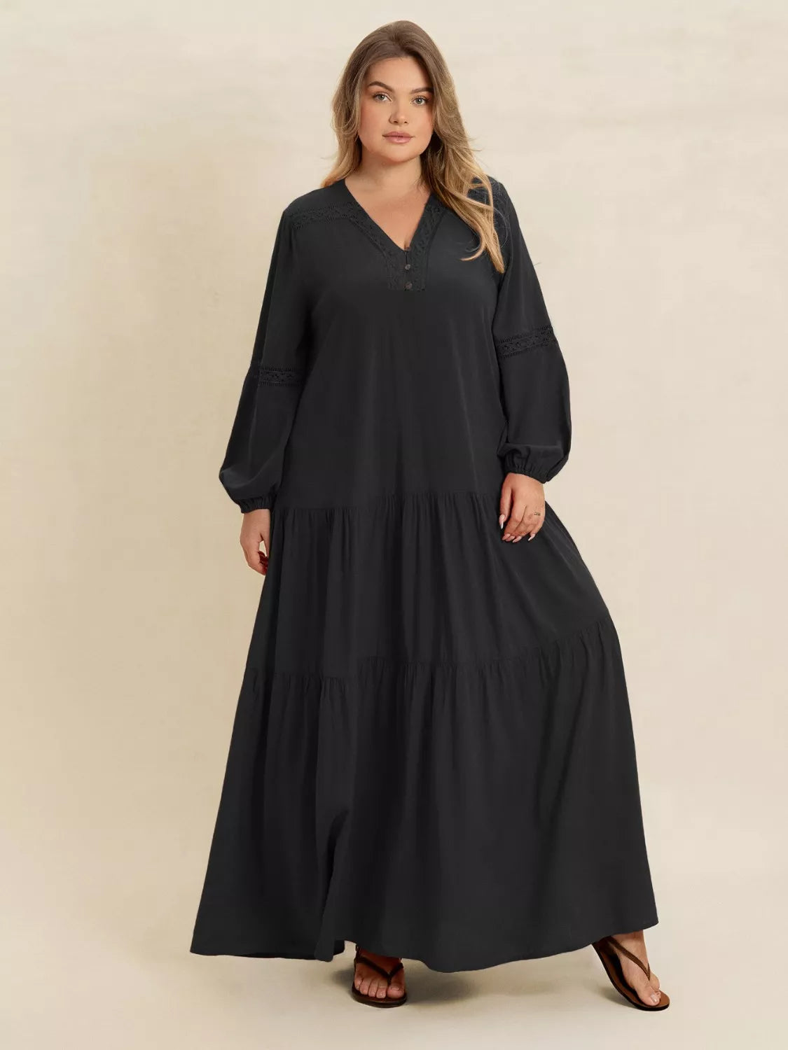 Woman wearing a black-colored tiered maxi dress with lace detail and long sleeves — elegant flowing boho dress from A Whimsical Affair.