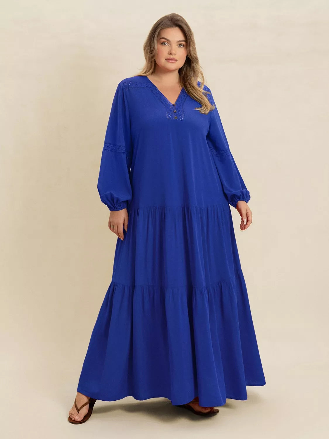 Woman wearing a blue-colored tiered maxi dress with lace detail and long sleeves — elegant flowing boho dress from A Whimsical Affair.