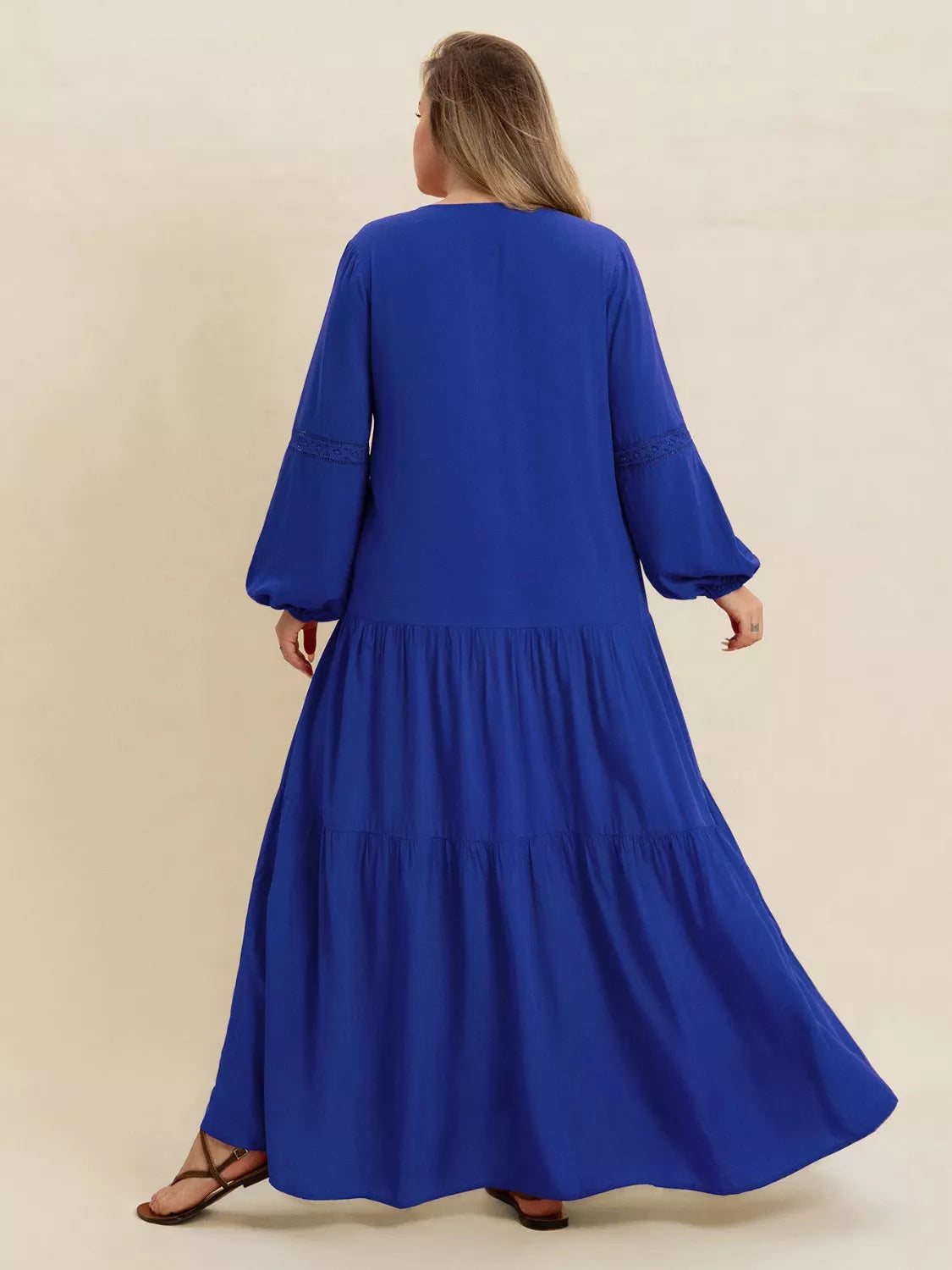 Woman wearing a blue-colored tiered maxi dress with lace detail and long sleeves — elegant flowing boho dress from A Whimsical Affair.