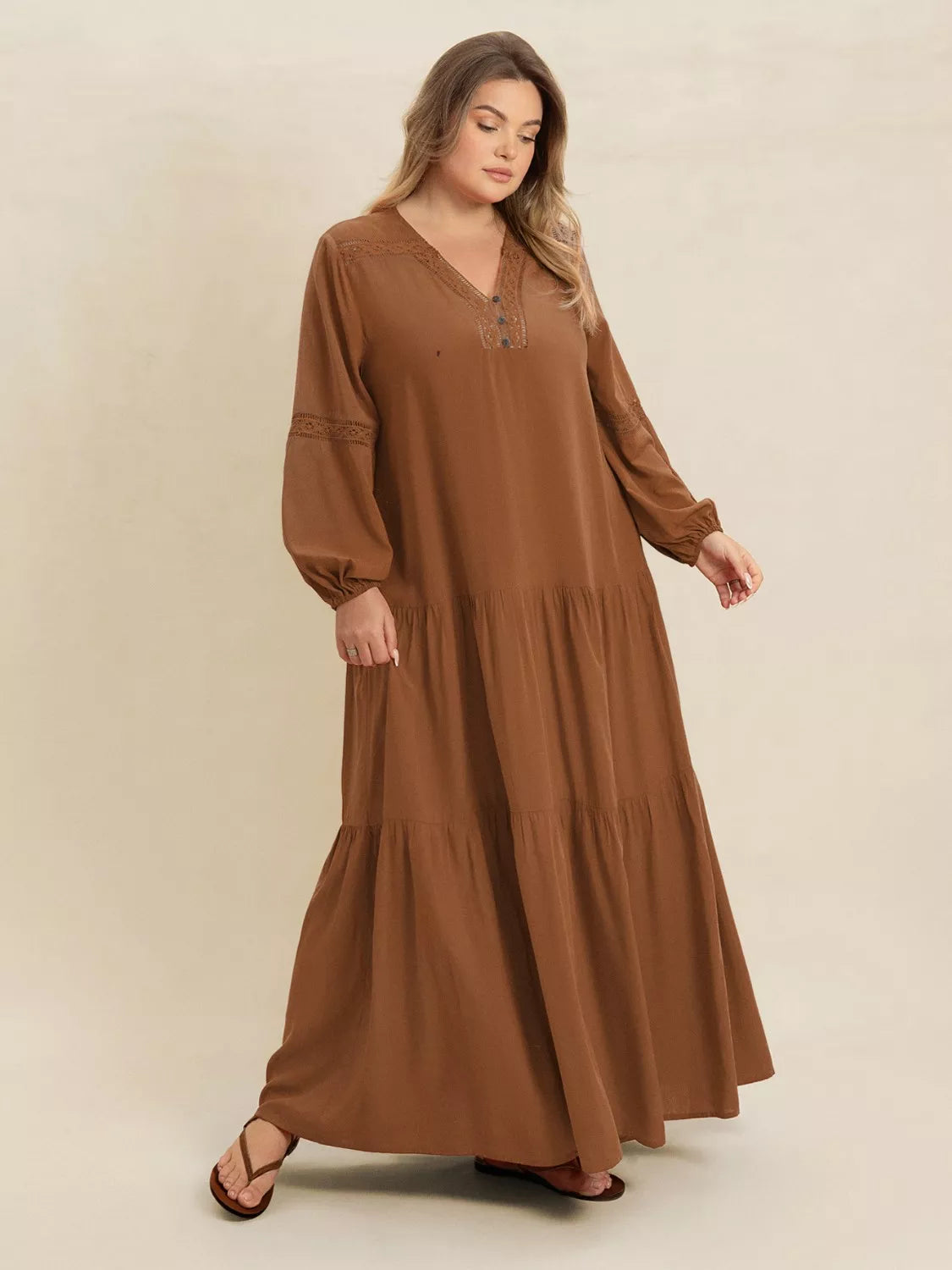 Woman wearing a camel-colored tiered maxi dress with lace detail and long sleeves — elegant flowing boho dress from A Whimsical Affair.