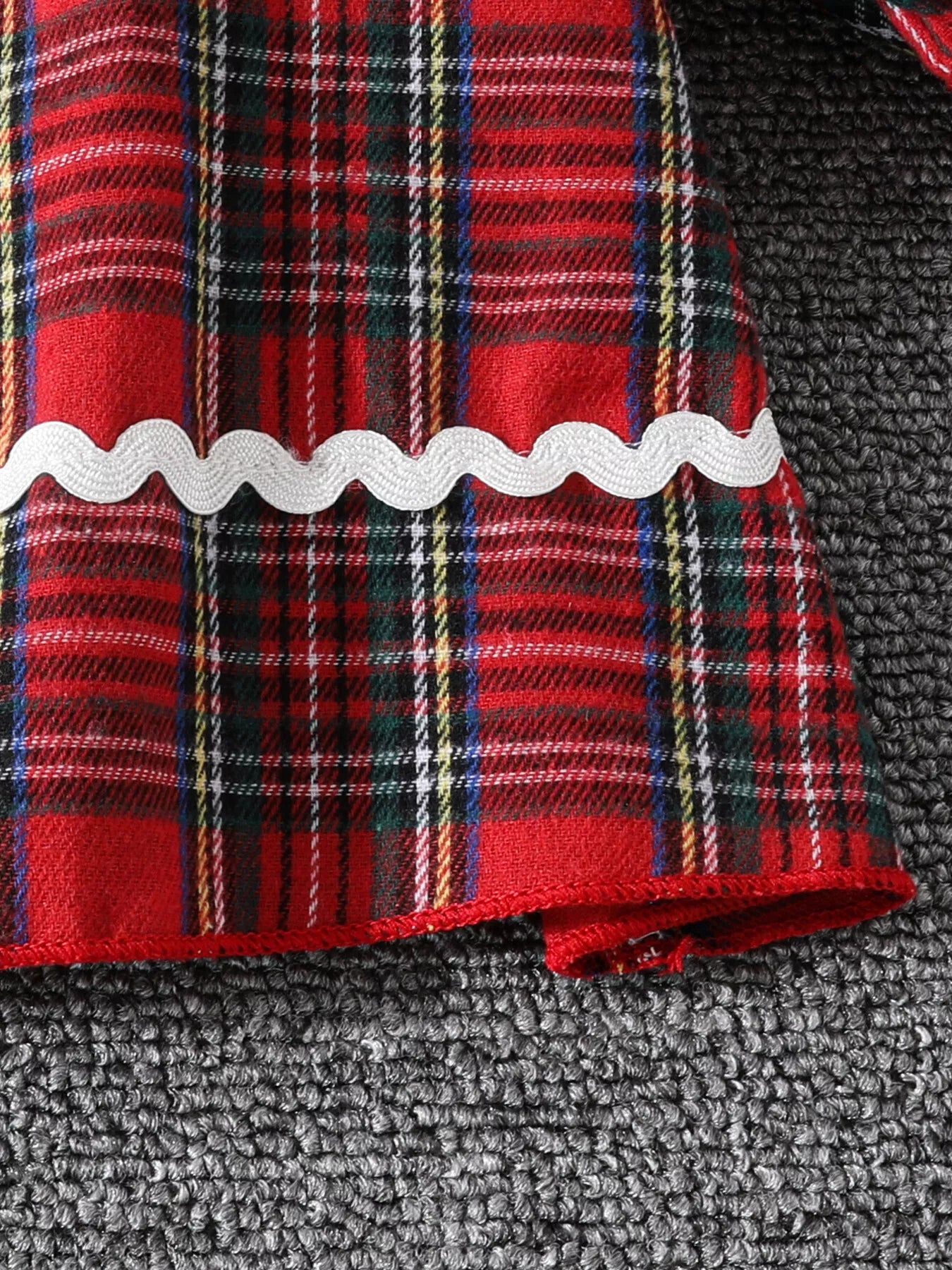 Close-up of Christmas tree embroidery and collar details on holiday tartan dress
