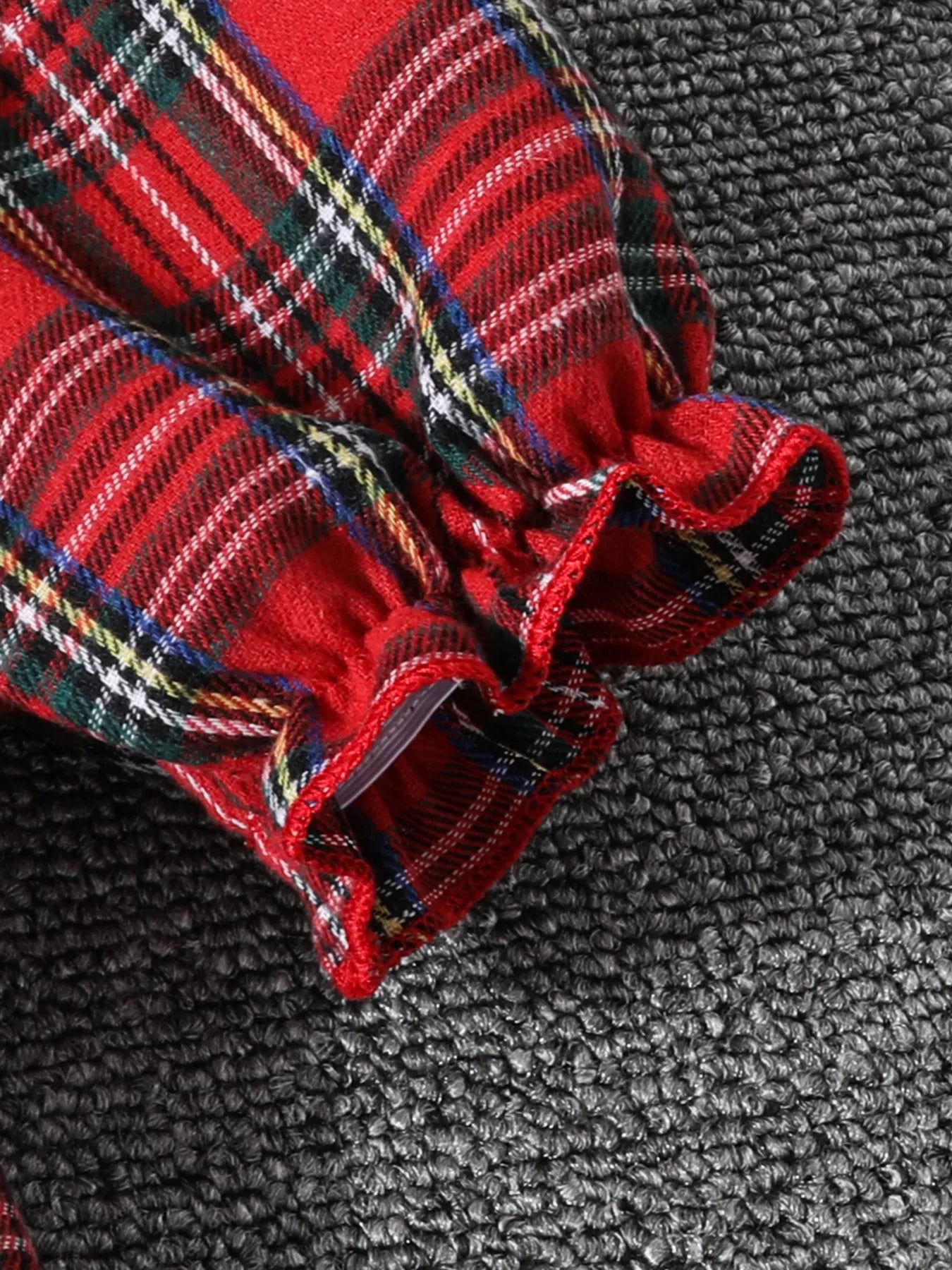 Close-up of Christmas tree embroidery and collar details on holiday tartan dress