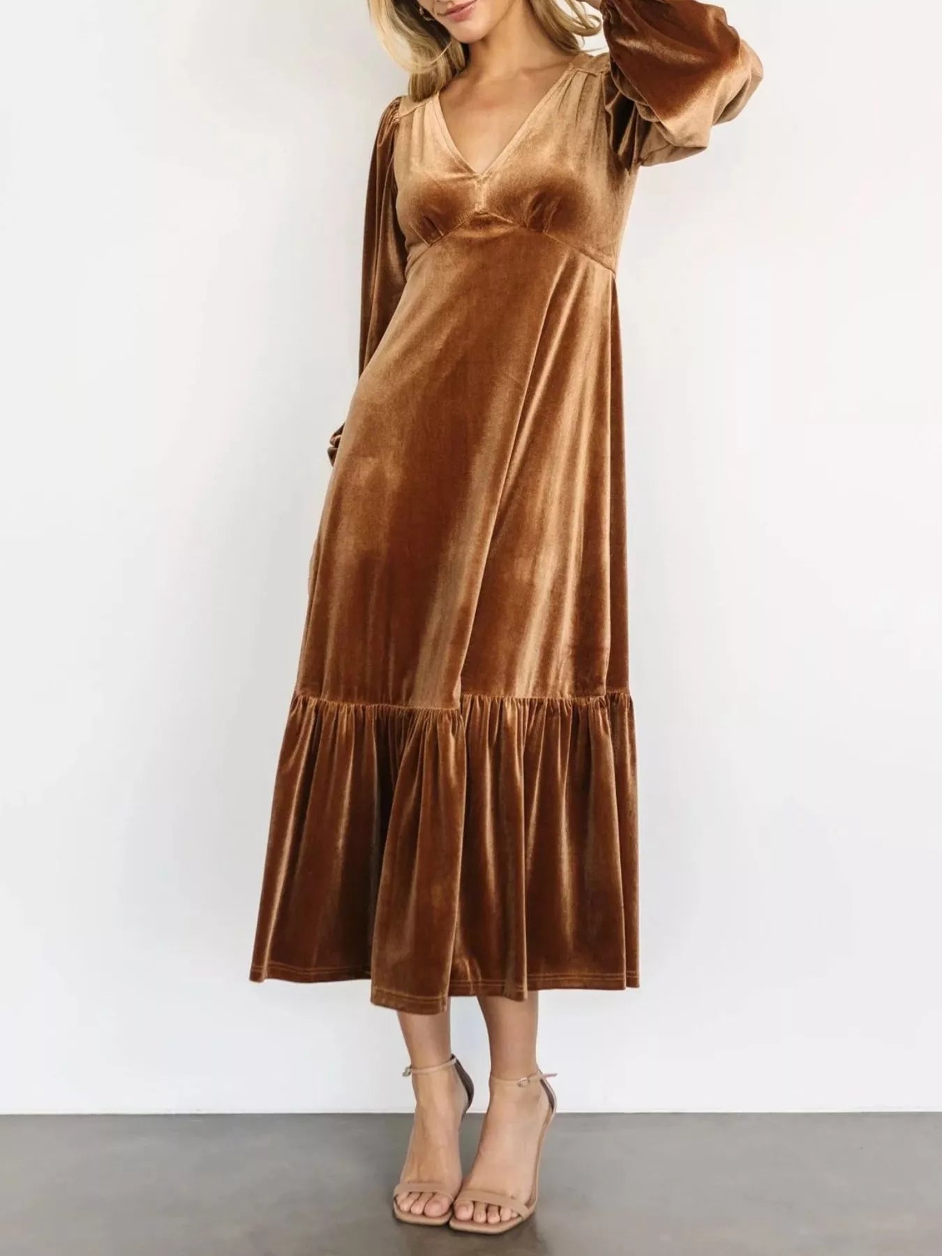 Woman wearing a gold velvet midi dress with long sleeves and tiered hem — elegant soft-touch holiday dress from A Whimsical Affair.
