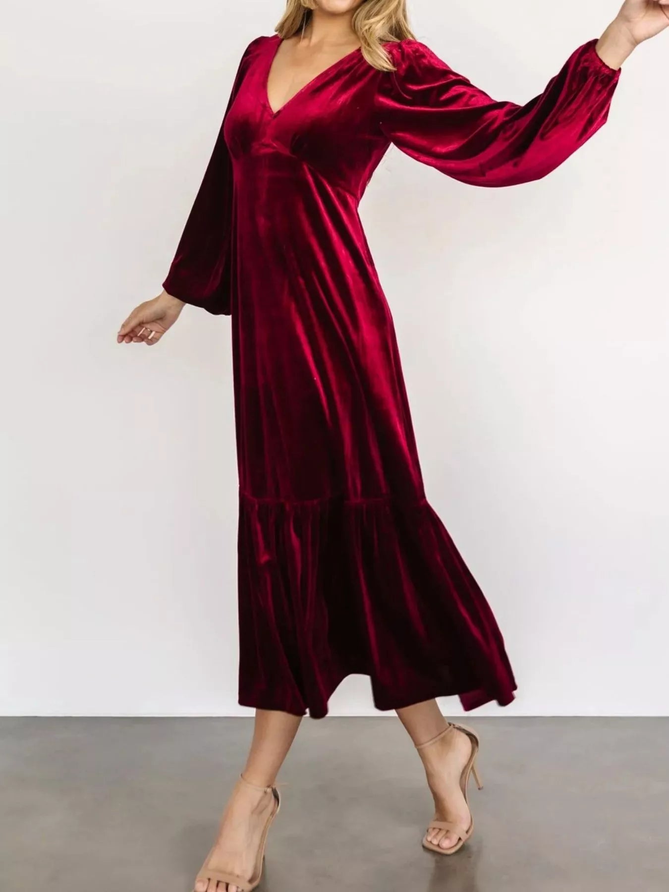 Woman wearing a red velvet midi dress with long sleeves and tiered hem — elegant soft-touch holiday dress from A Whimsical Affair.