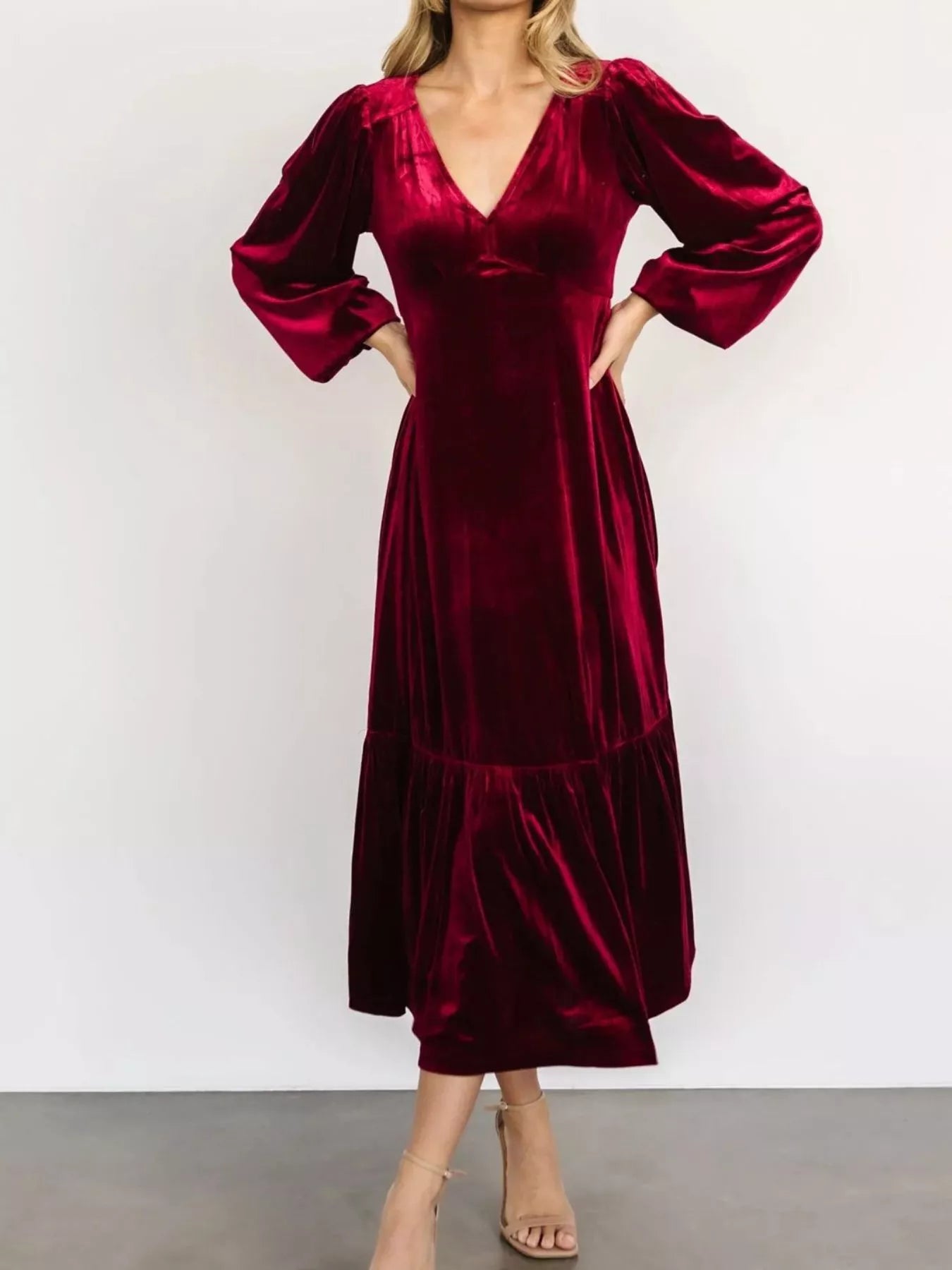 Woman wearing a red velvet midi dress with long sleeves and tiered hem — elegant soft-touch holiday dress from A Whimsical Affair.