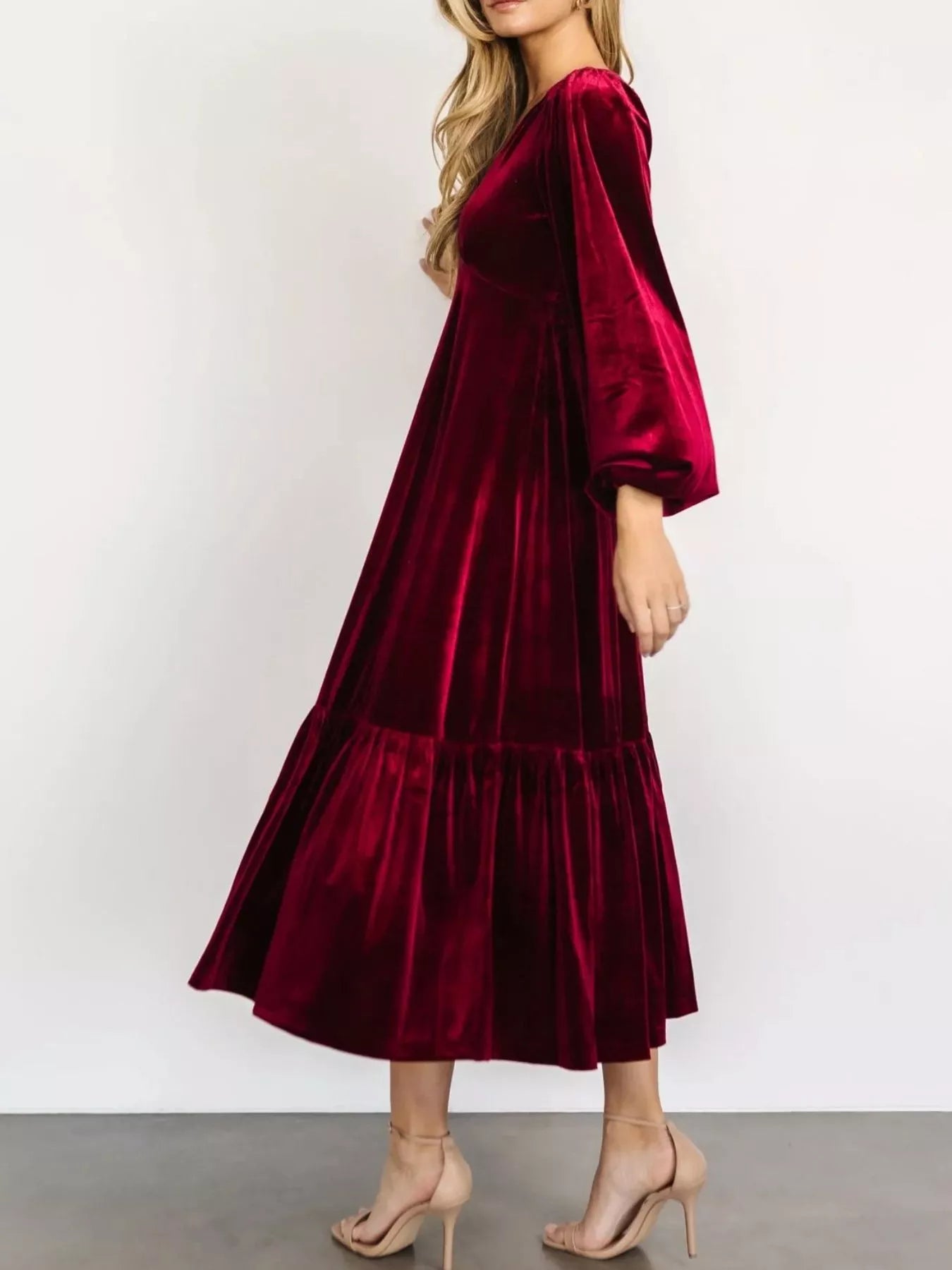 Woman wearing a red velvet midi dress with long sleeves and tiered hem — elegant soft-touch holiday dress from A Whimsical Affair.