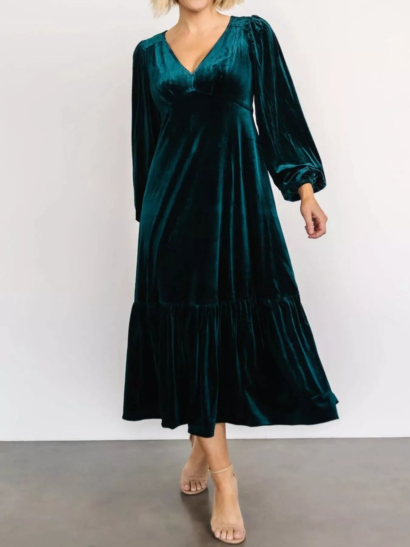 Woman wearing a peacock blue velvet midi dress with long sleeves and tiered hem — elegant soft-touch holiday dress from A Whimsical Affair.