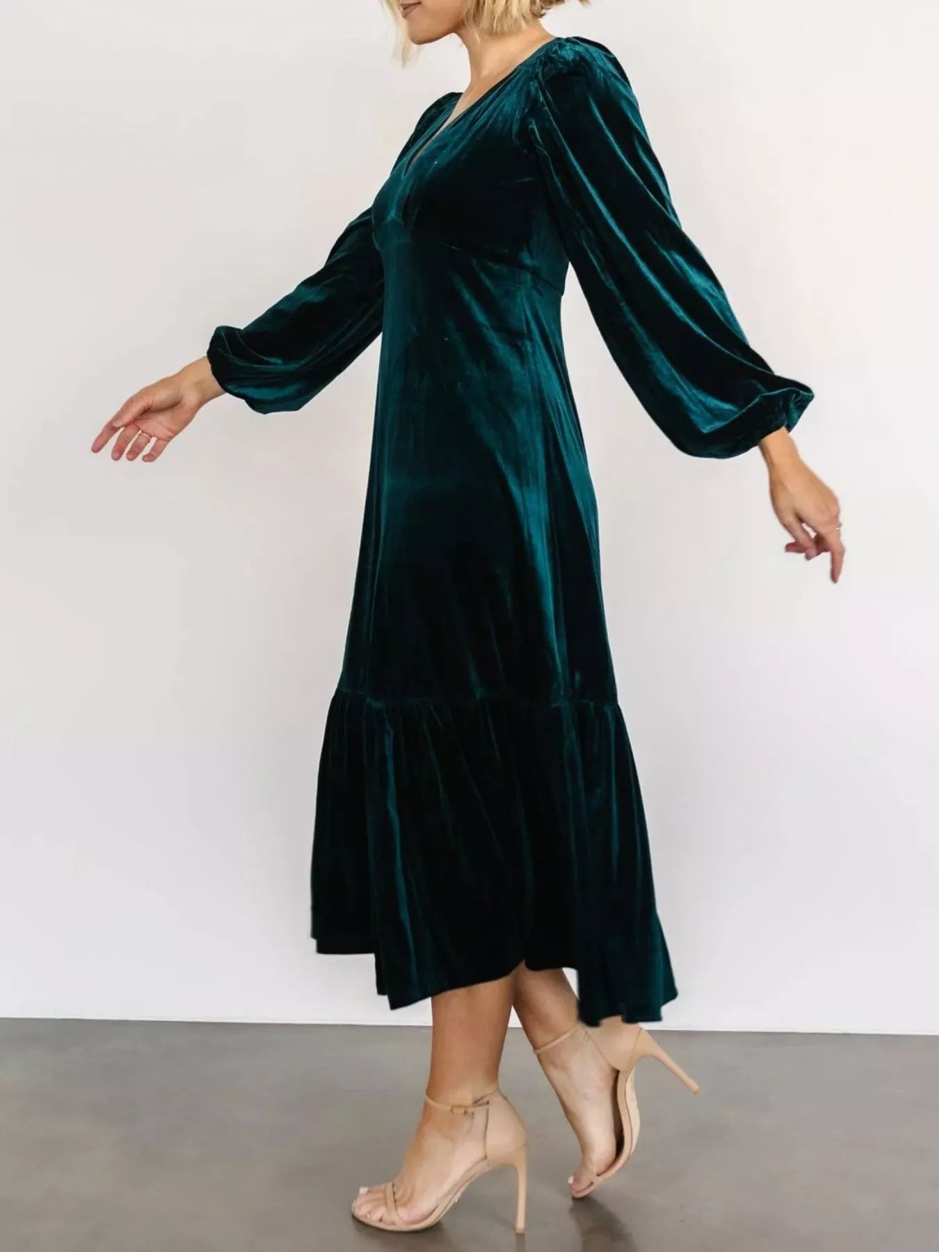 Woman wearing a peacock blue velvet midi dress with long sleeves and tiered hem — elegant soft-touch holiday dress from A Whimsical Affair.