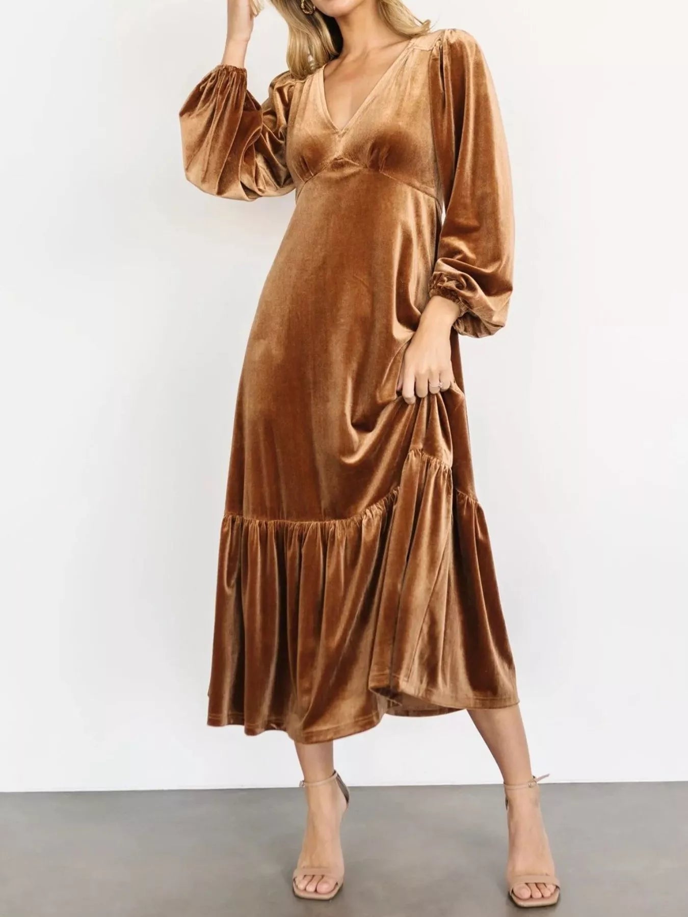 Woman wearing a gold velvet midi dress with long sleeves and tiered hem — elegant soft-touch holiday dress from A Whimsical Affair.