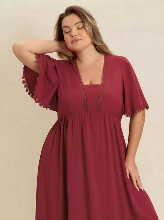 Plus-size woman wearing wine red lace trim maxi dress with flutter sleeves