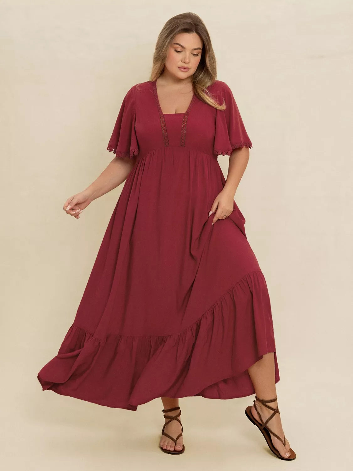 Plus-size woman wearing wine red lace trim maxi dress with flutter sleeves