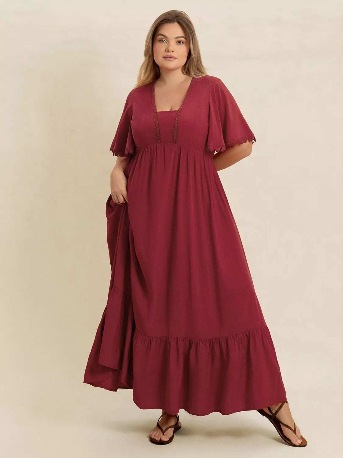 Plus-size woman wearing wine red lace trim maxi dress with flutter sleeves