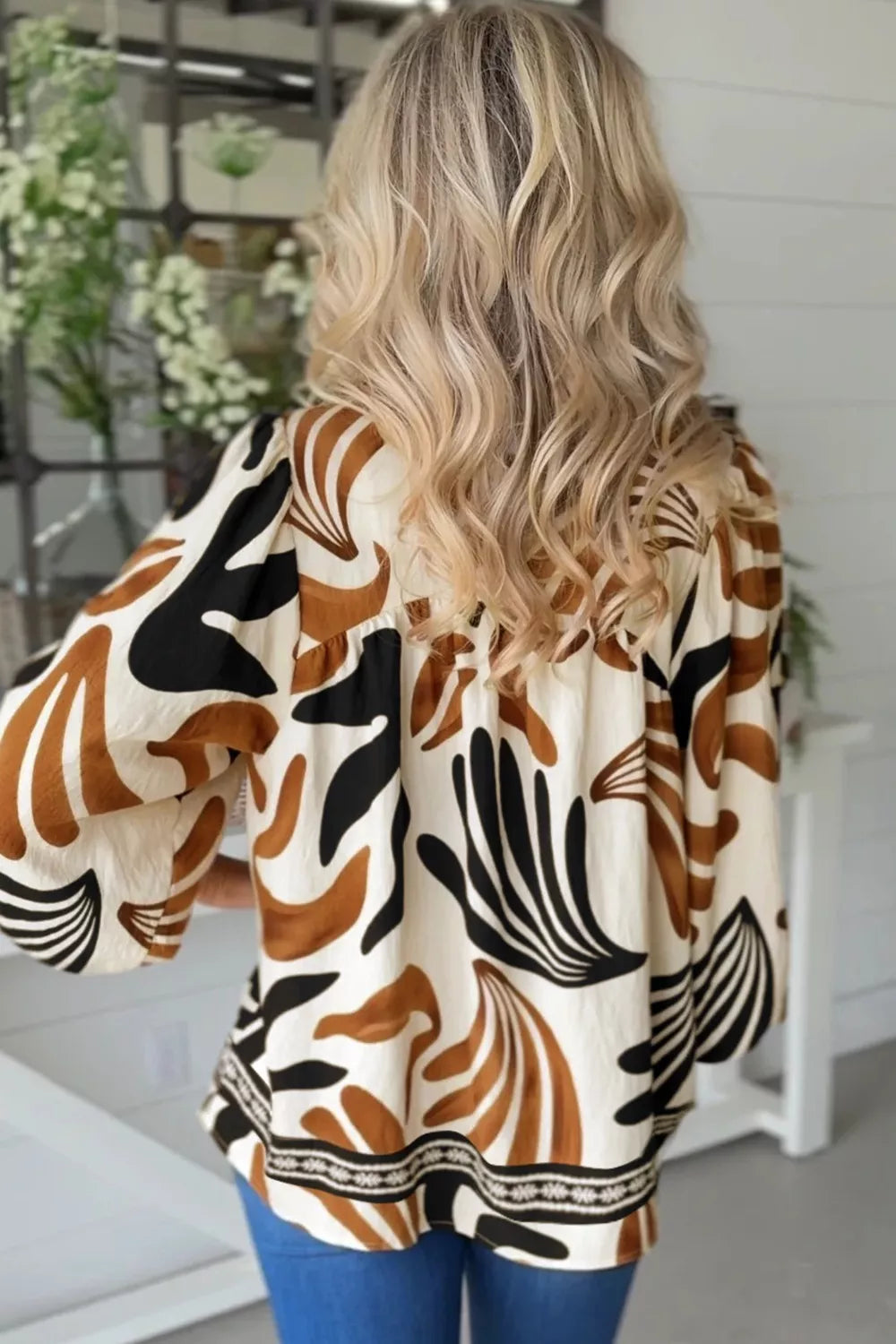 Abstract leaf print V-neck blouse with relaxed fit and border detail