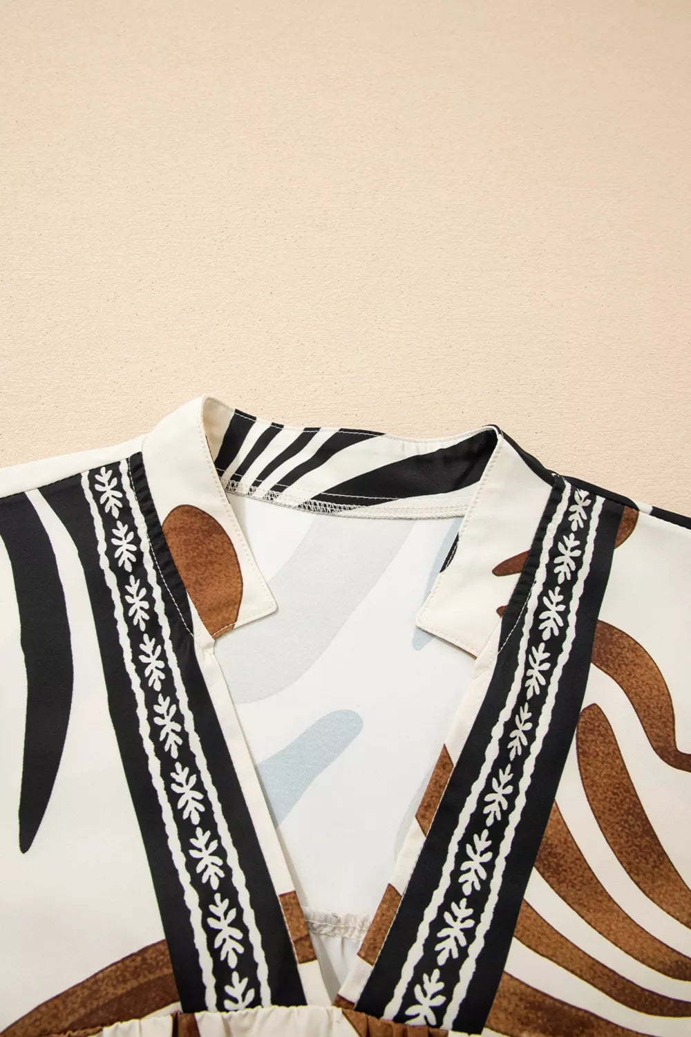Abstract leaf print V-neck blouse with relaxed fit and border detail