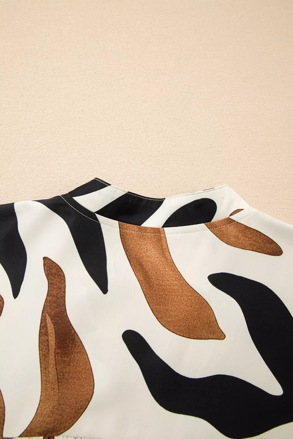 Abstract leaf print V-neck blouse with relaxed fit and border detail