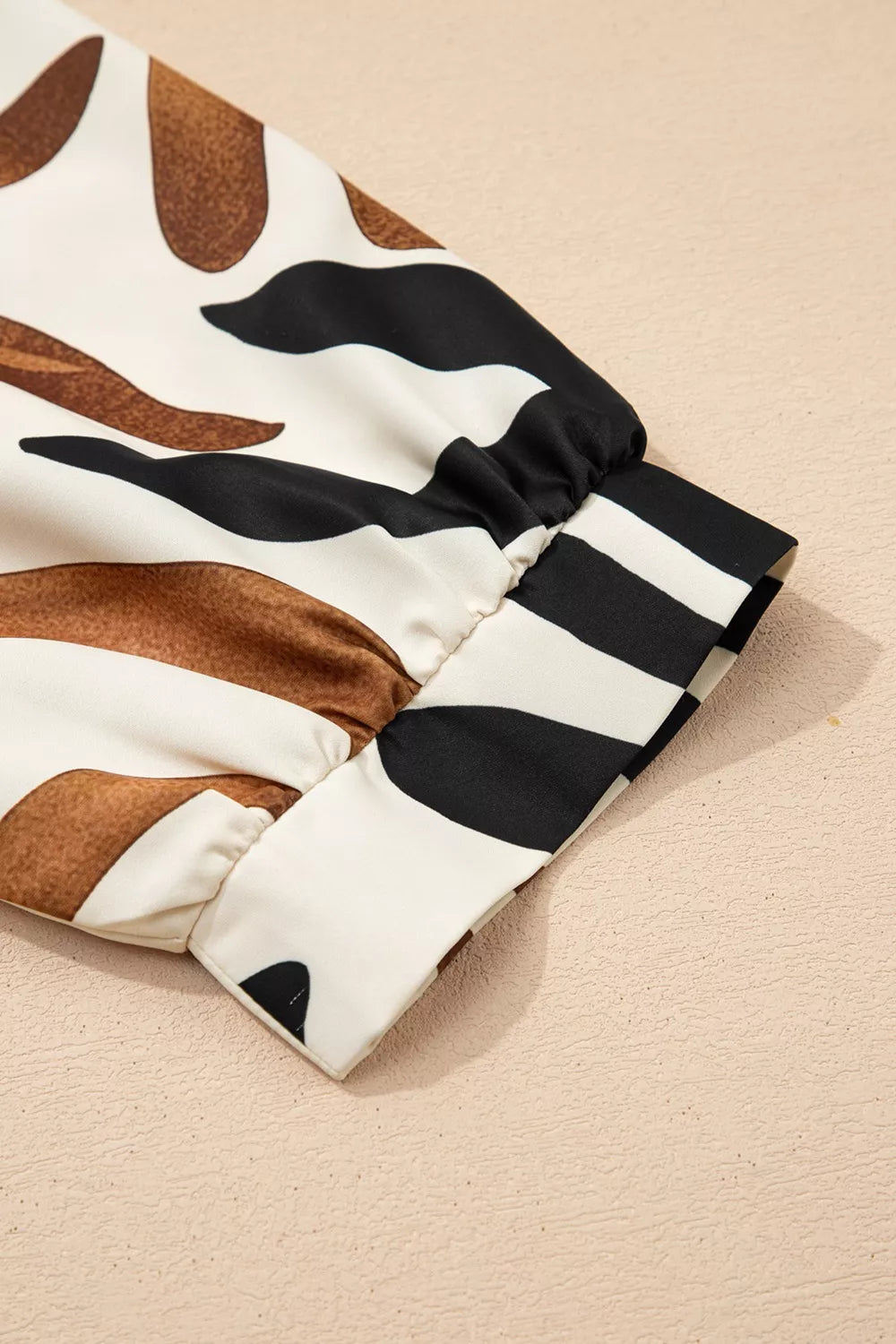Abstract leaf print V-neck blouse with relaxed fit and border detail