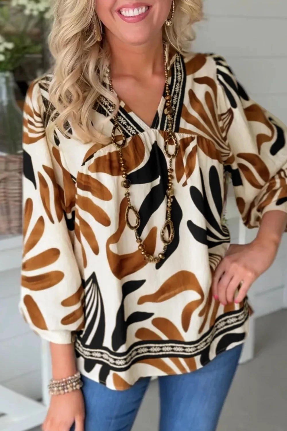 Abstract leaf print V-neck blouse with relaxed fit and border detail