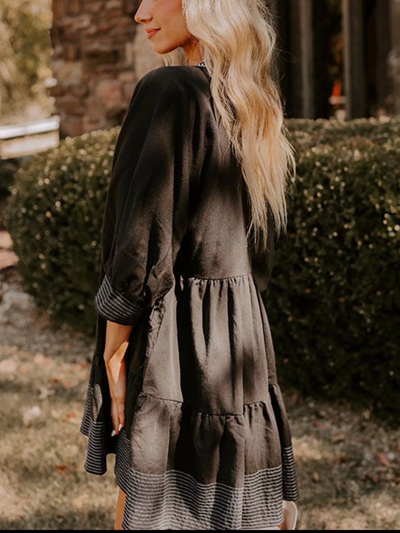 Woman wearing brown Autumn Ease Tiered Dress with 3/4 sleeves and striped hem