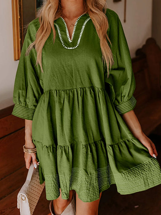 Woman wearing green Autumn Ease Tiered Dress with 3/4 sleeves and striped hem