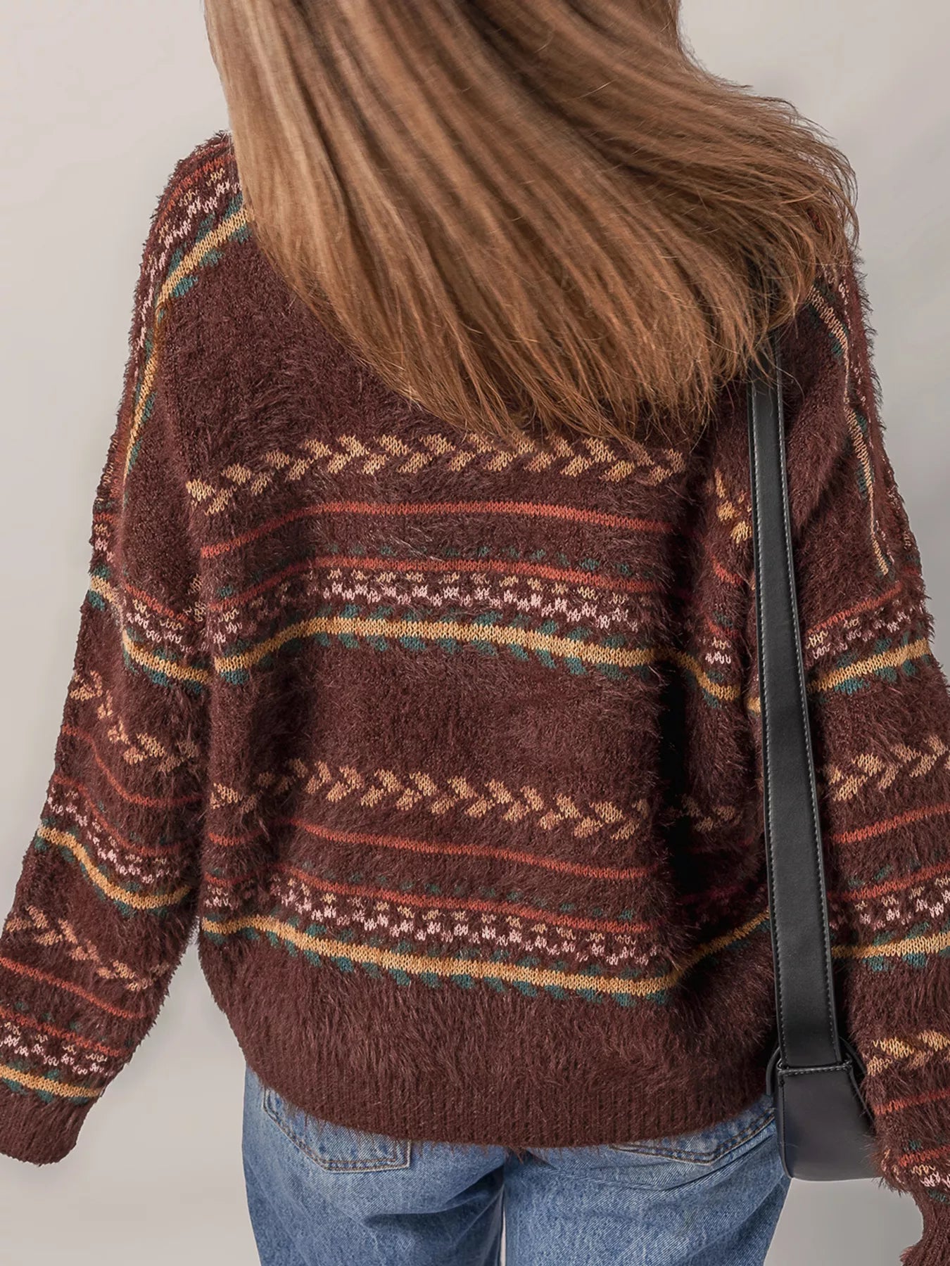 Brown oversized fuzzy sweater with fair isle-style stripes in warm earthy tones.