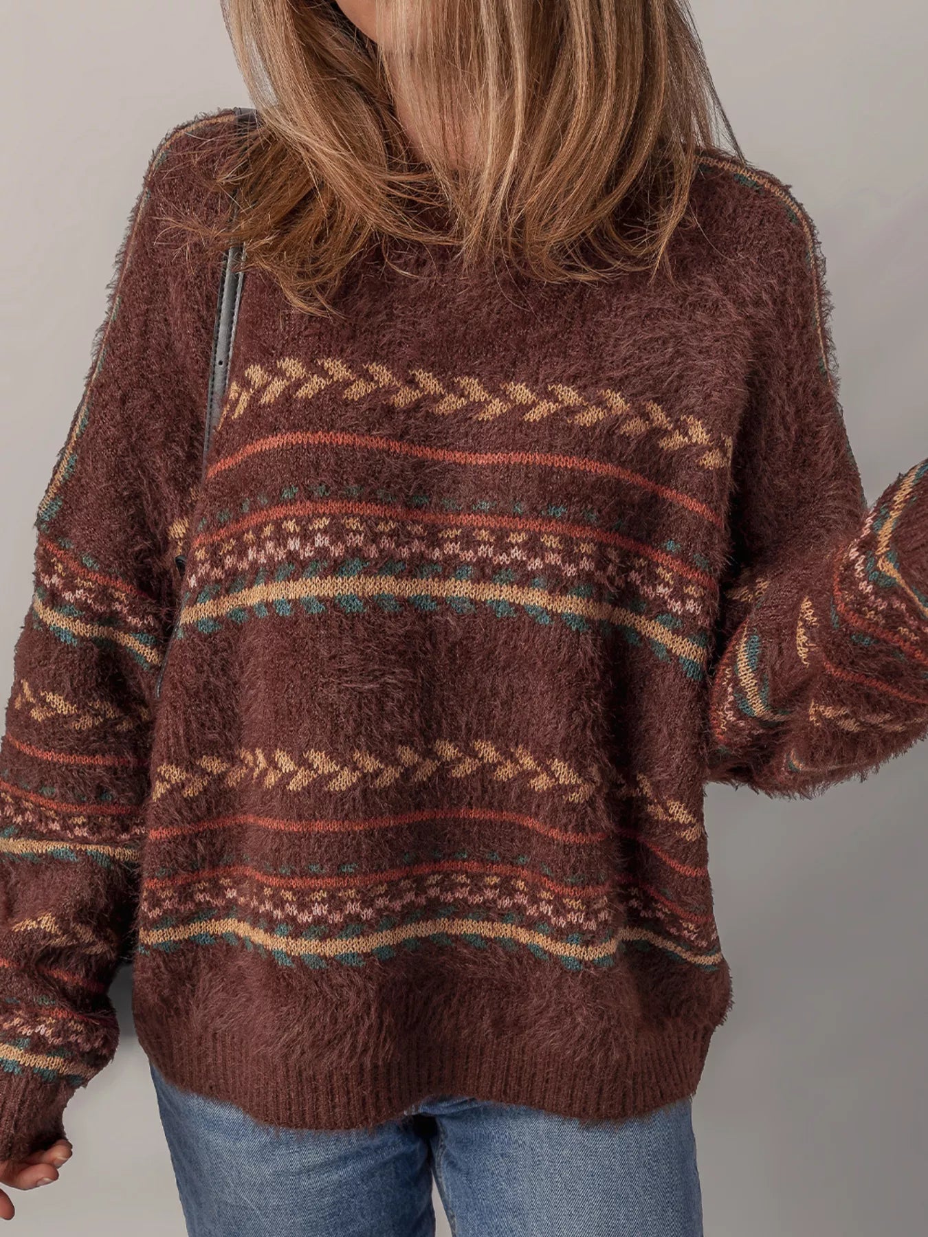 Brown oversized fuzzy sweater with fair isle-style stripes in warm earthy tones.