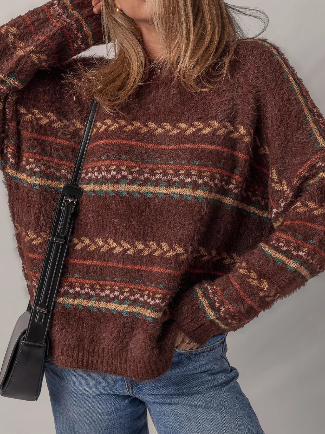Brown oversized fuzzy sweater with fair isle-style stripes in warm earthy tones.