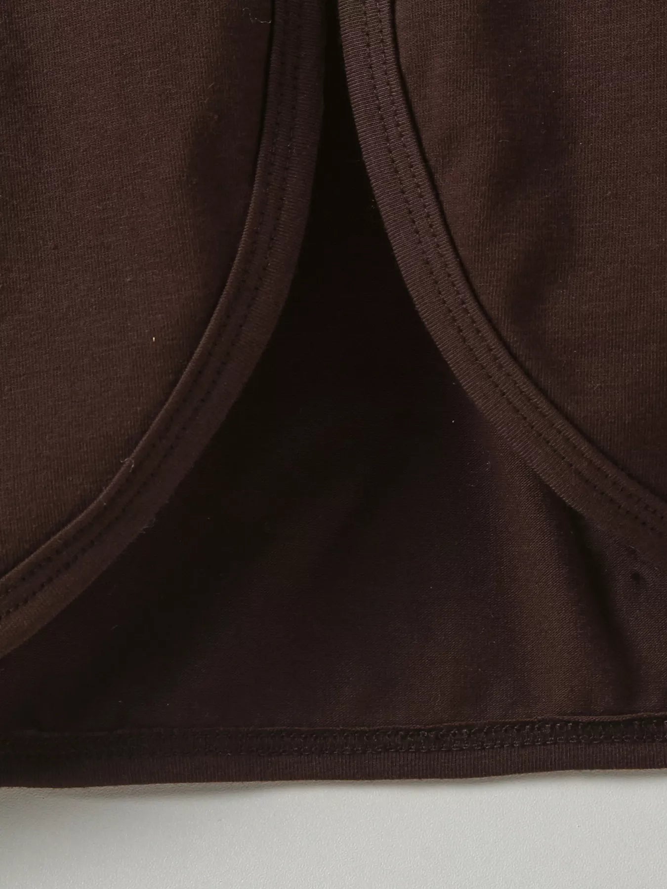 Three-piece baby girl outfit with orange plaid turkey dress, brown cardigan, and matching plaid headband on a beige background with fall leaves.