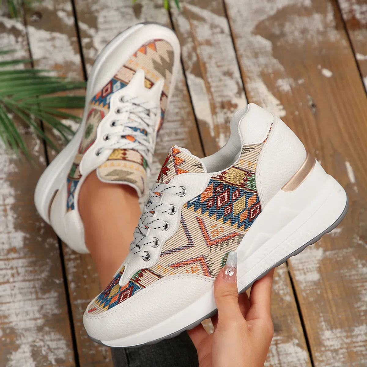 A pair of Aztec Rise Wedge Sneakers with colorful geometric patterns, lace-up design, and hidden wedge heel in cream and khaki color options
