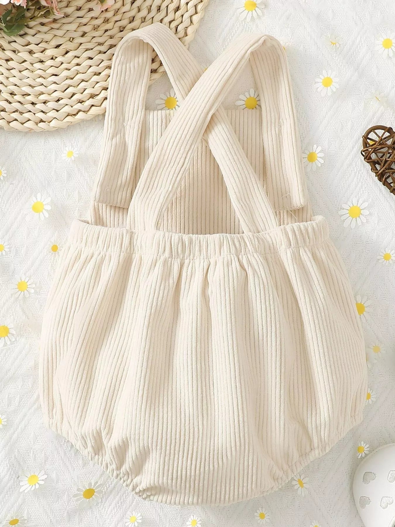 Cream ribbed corduroy baby romper with button straps, snap bottom, and textured chicken appliqué on the front.