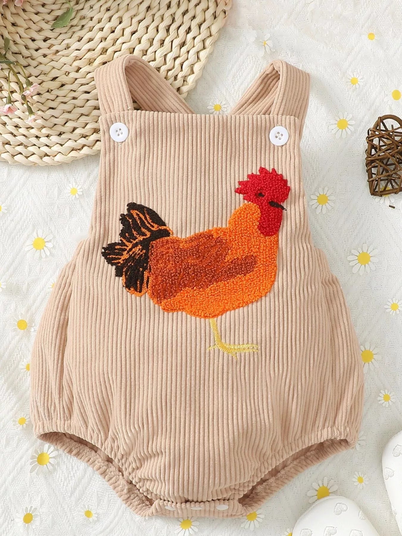 Cream ribbed corduroy baby romper with button straps, snap bottom, and textured chicken appliqué on the front.