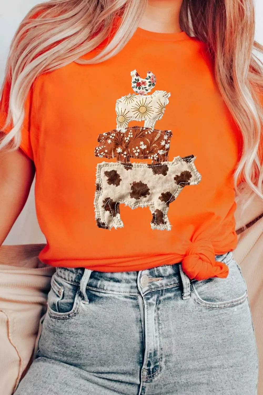 Orange short sleeve graphic tee with stacked patchwork-style farm animals including a cow, pig, sheep, and chicken.