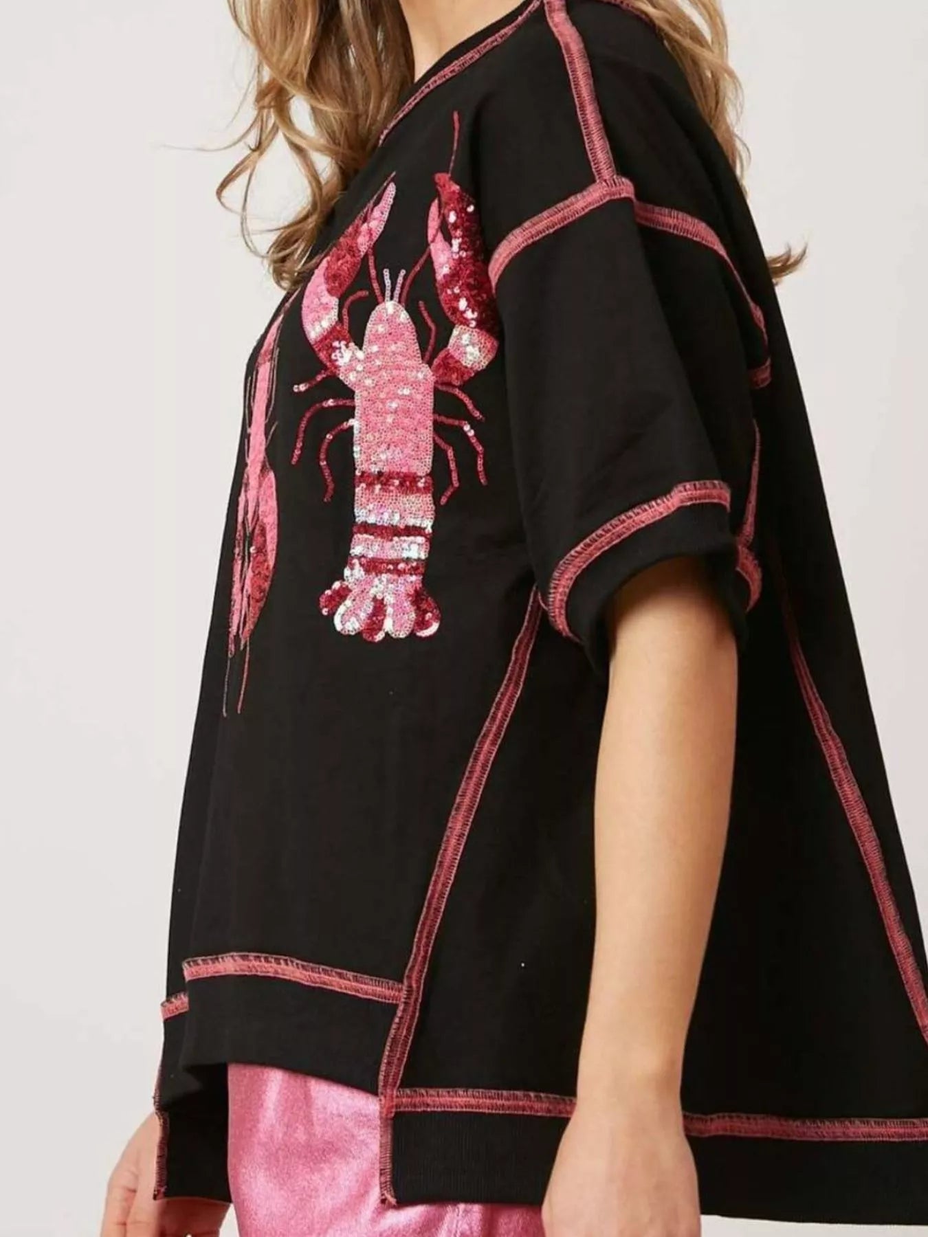 Oversized black tee with pink glitter lobster print and contrast stitching.