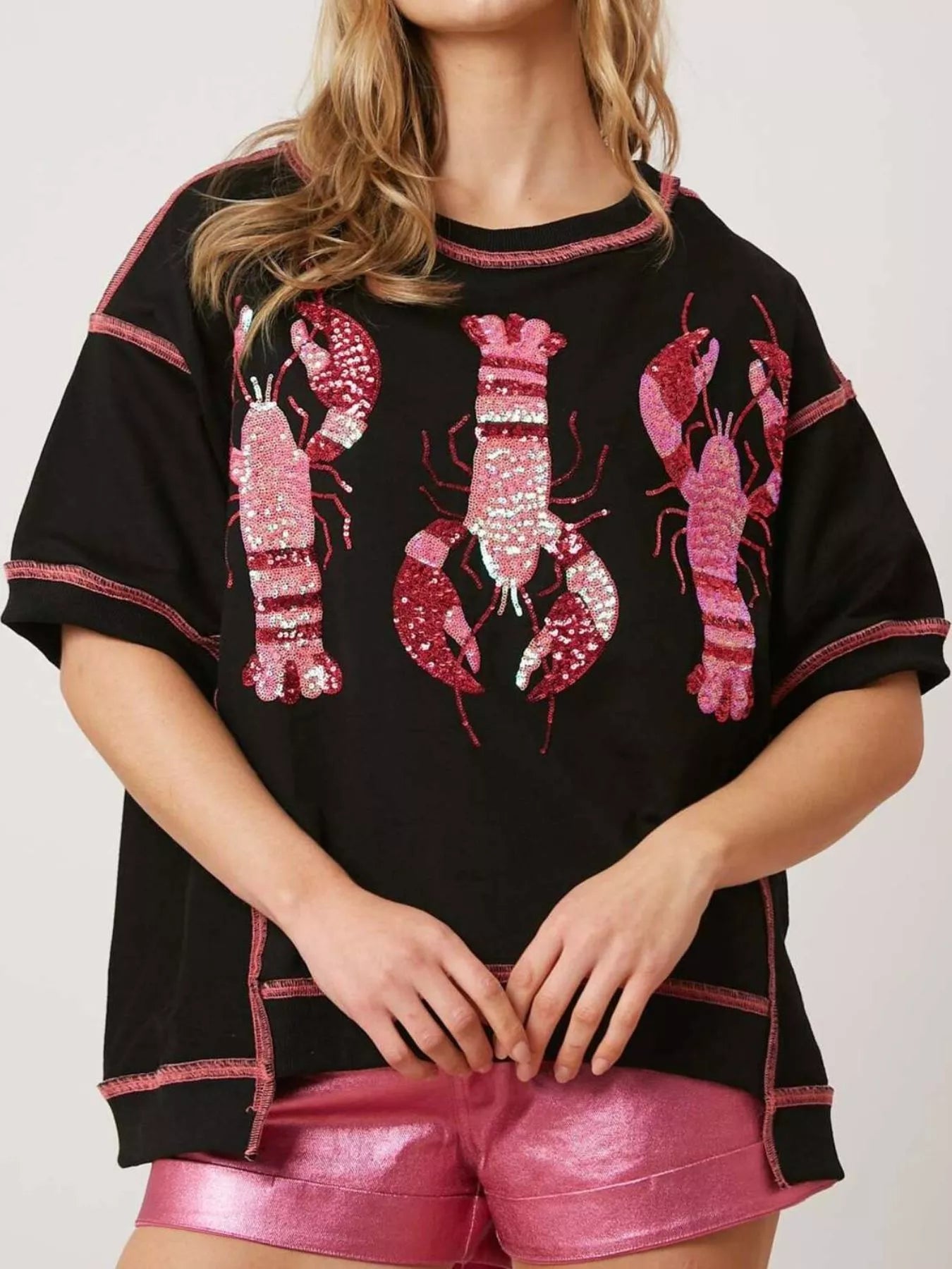 Oversized black tee with pink glitter lobster print and contrast stitching.