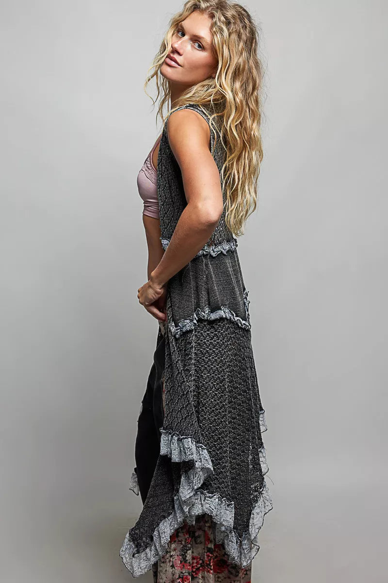 Sleeveless crochet vest with openwork texture, lace details, cascading ruffle hem, and lightweight boho layering style.