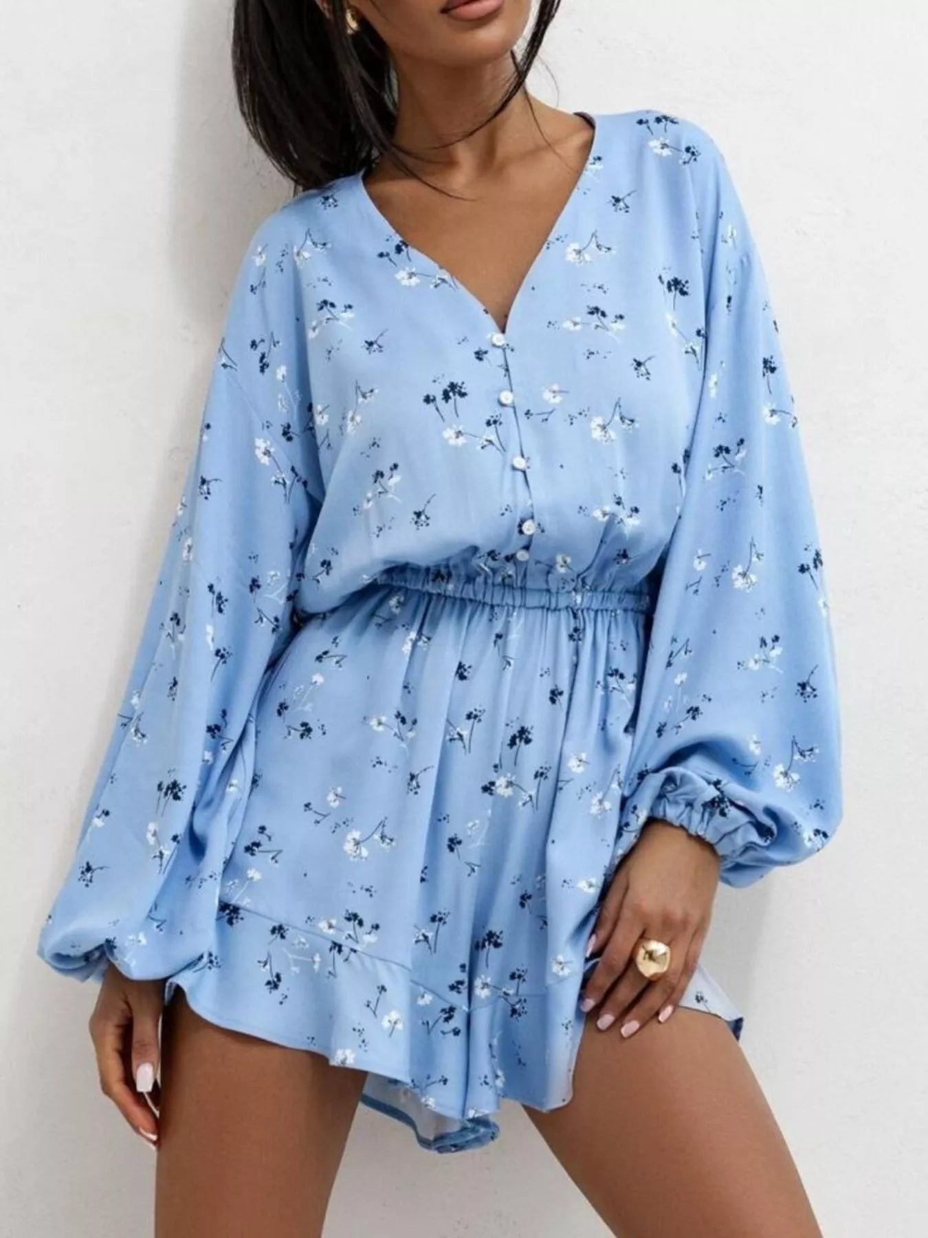Bloom & Breeze Romper in blue floral with V-neckline and ruffle hem.