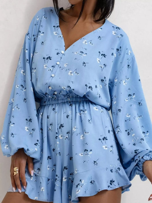 Bloom & Breeze Romper in blue floral with V-neckline and ruffle hem.