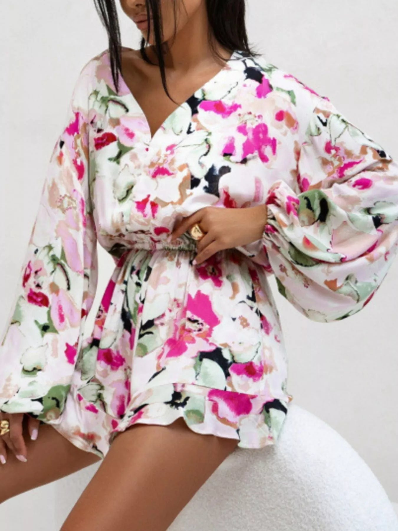 Bloom & Breeze Romper in white and pink floral print with long sleeves and elastic waist.