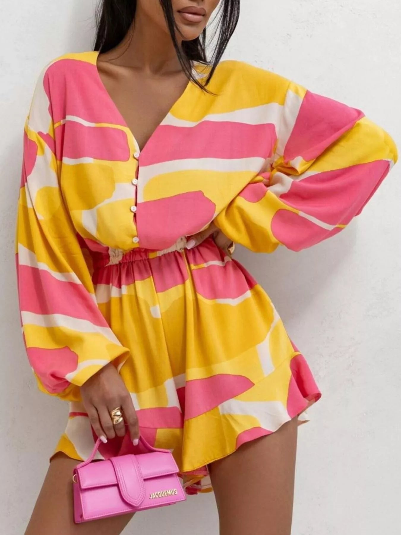 Bloom & Breeze Romper in bold yellow and pink abstract print with ruffle detail.