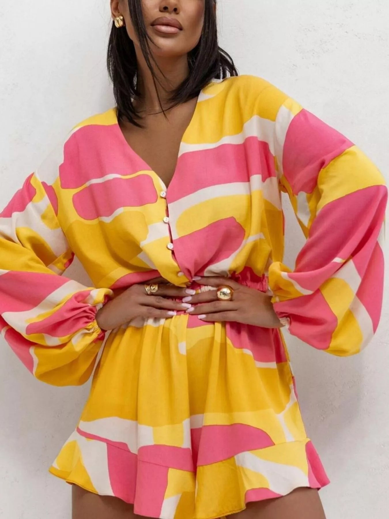 Bloom & Breeze Romper in bold yellow and pink abstract print with ruffle detail.