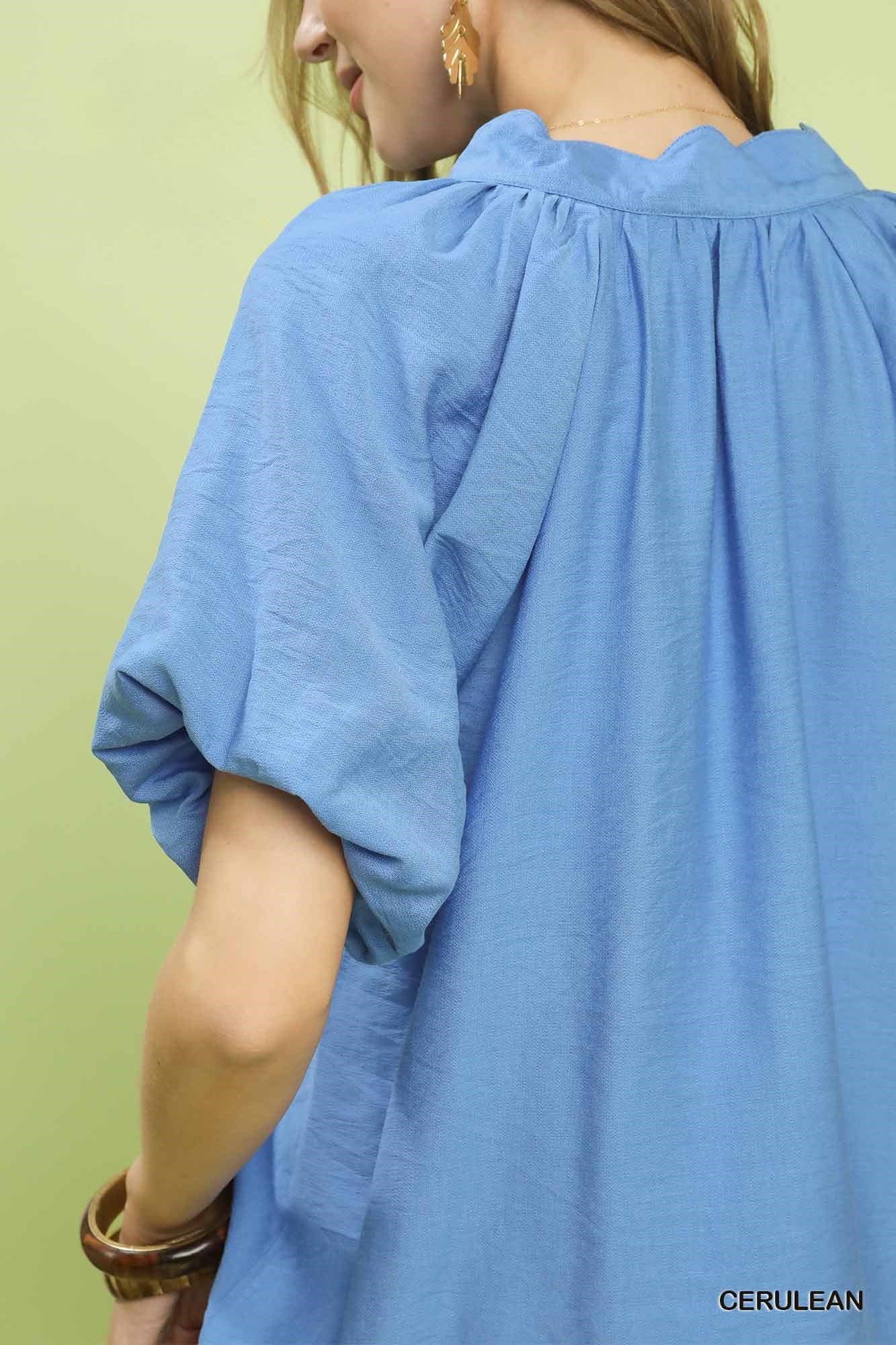 Blue relaxed top with oversized floral embroidery at hem