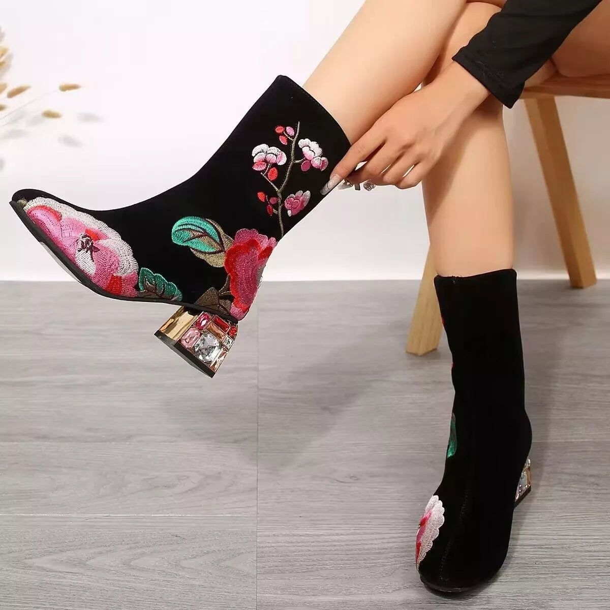 Black suede embroidered ankle boots with floral detailing and rhinestone mid heel