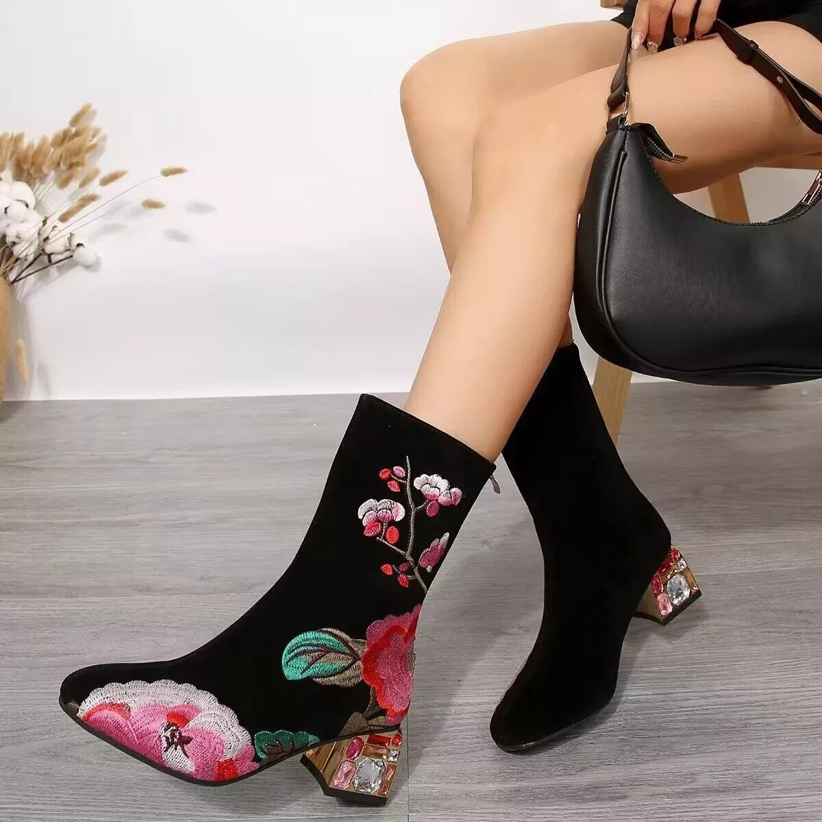 Black suede embroidered ankle boots with floral detailing and rhinestone mid heel
